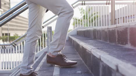 Sección-Baja-De-Un-Hombre-Asiático-Con-Mochila-Subiendo-Las-Escaleras-En-El-Parque-Corporativo