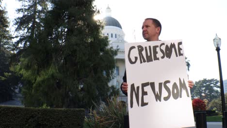 male political protester with gruesome newsom sign slider dolly tracking shot