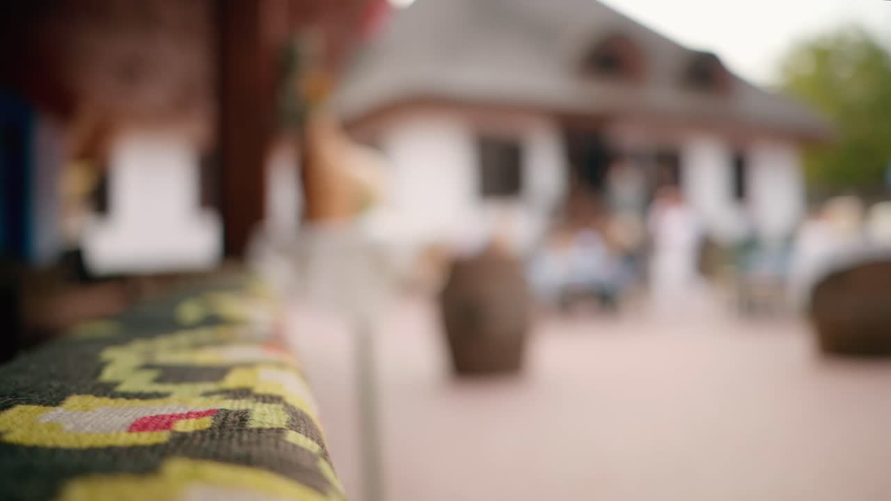 Elementi tradizionali e persone che si rilassano in un ristorante-azienda vinicola in un villaggio, Moldavia. Vino e asciugamano tradizionali, case tradizionali
