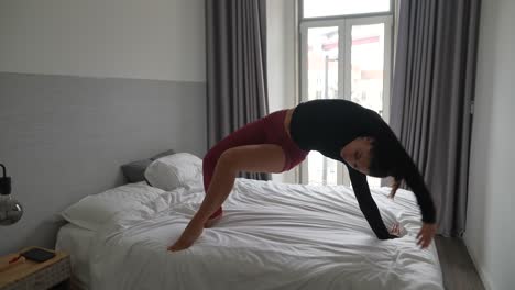 mujer haciendo posturas de yoga en su dormitorio