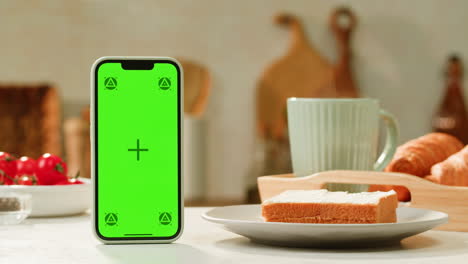green screen smartphone on breakfast table