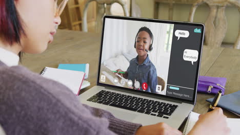 composition of asian schoolgirl on laptop online learning with african american schoolboy