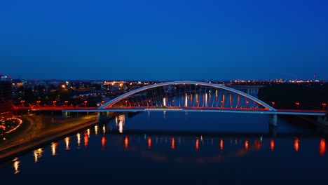 appolo bridge over the danube in bratislava, slovakia. city lights are switched on at night time