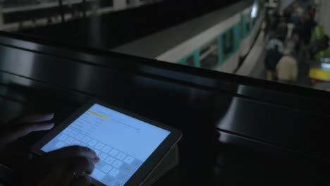 Woman-typing-message-on-pad-in-subway