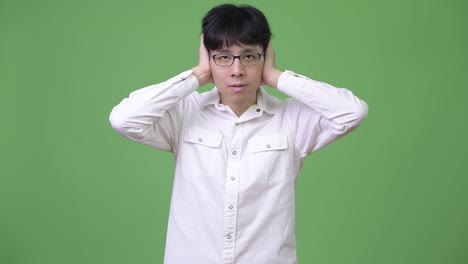 young asian businessman covering ears as hear no evil concept