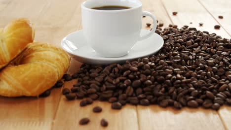 café con granos de café tostados y croissants