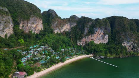 breathtaking view of a secluded bay with turquoise water, surrounded by towering cliffs covered in lush green vegetation