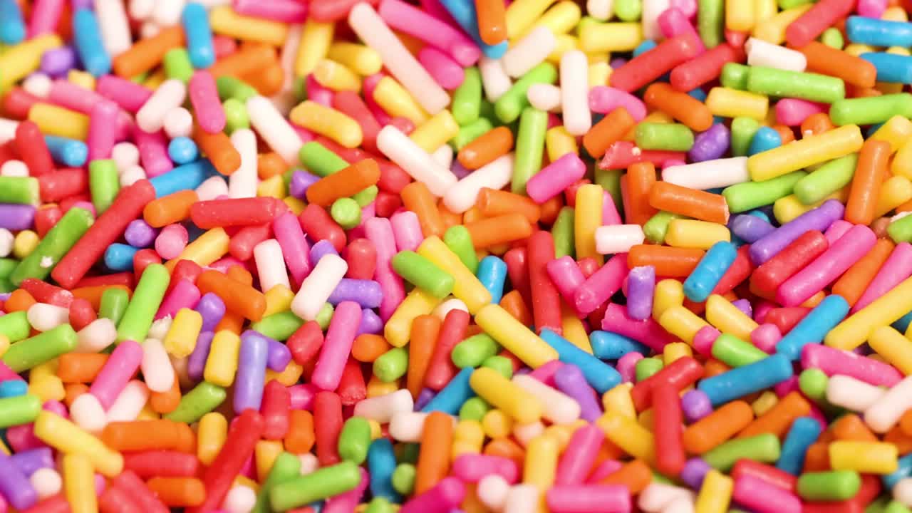 A vibrant close-up view of colorful sprinkles in dynamic motion, showcasing their bright and cheerful hues.