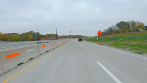 pov podczas jazdy przez plac budowy na autostradzie międzystanowej i74 w pobliżu rzeki mississippi późną jesienią w pochmurny dzień w moline illinois