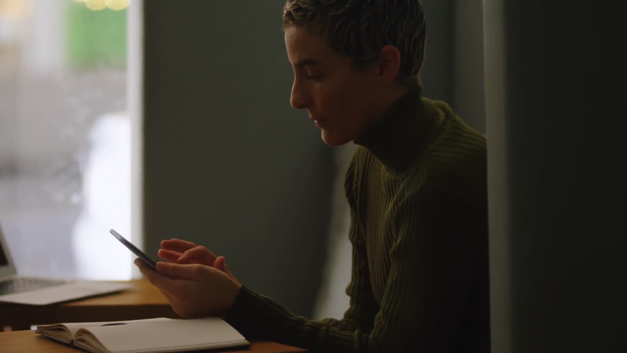 ejecutivo usando teléfono móvil en la cafetería de la oficina 4k