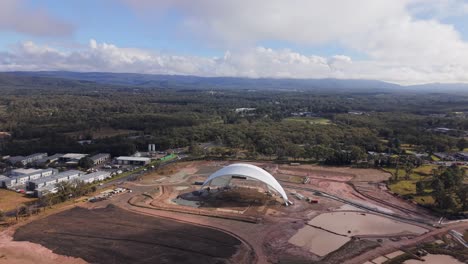 aerial of abandoned stadium construction site in morisset, nsw with exposed framework, orbit