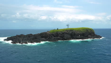 Toma-De-Seguimiento-Aéreo-De-Una-Hermosa-Isla-Aislada-En-El-Paisaje-Del-Océano-Azul