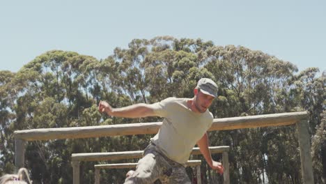 diverse group of soldiers going over and under hurdles on army obstacle course in the sun