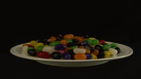 Sugar-snack-platter:-Jelly-beans-rotate-isolated-on-black-background