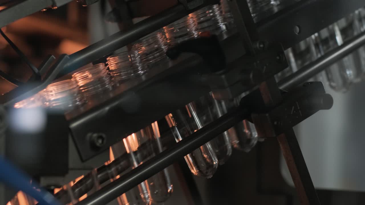 Automatic filling machine pours water into plastic PET bottles at modern beverage plant
