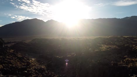 toma aérea del amanecer detrás de las montañas con paisaje nublado