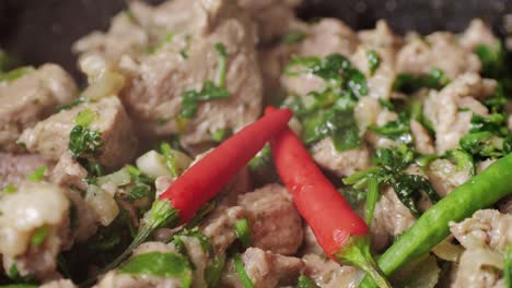 chicken or pork stew with red and green pepper onion, and spices cooking in a frying pan. traditional mexican cuisine, tacos preparation, ragout.