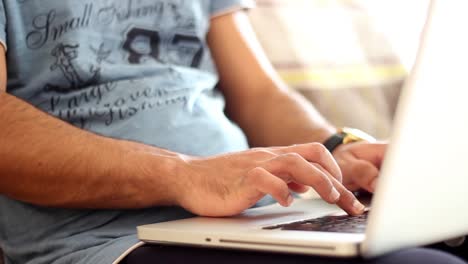 joven trabajador independiente que trabaja desde casa a través de una computadora portátil primer plano de manos masculinas escribiendo en la computadora 1