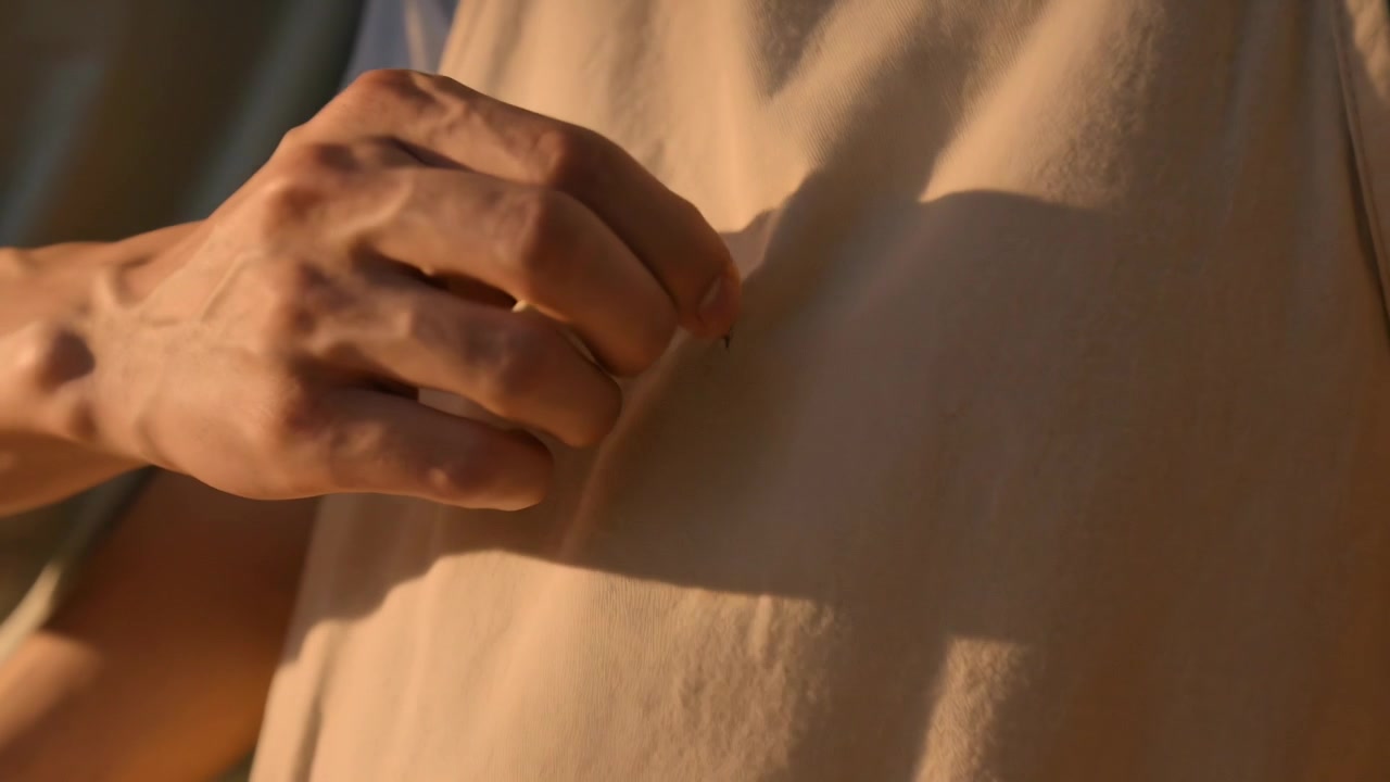 Reaching ringed hand touching apron-wearing partner in kitchen, finding and removing small thread