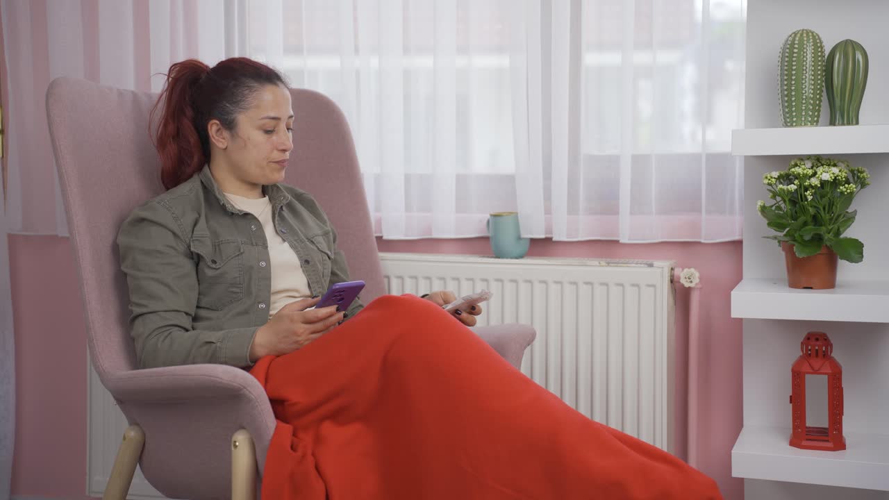 Kvinde, der læner sig op ad en radiator og kigger på en høj regning