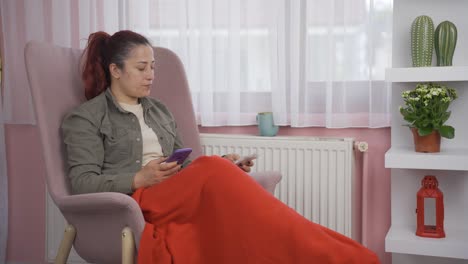 mujer apoyada en el calentador mirando la factura alta.