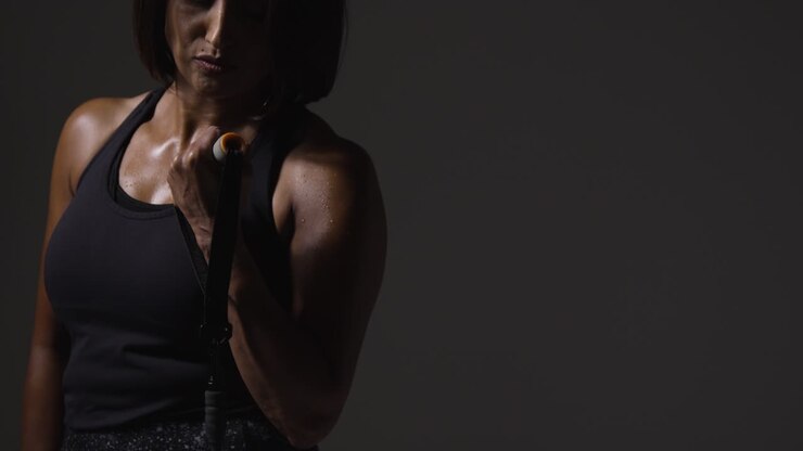 Primo piano in studio di donna matura in abbigliamento sportivo che si allena con una fascia di resistenza 3