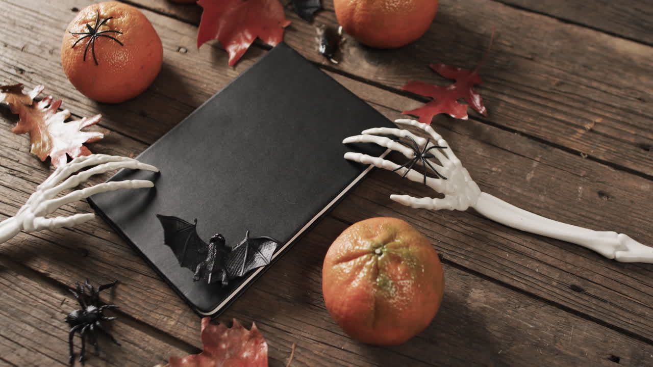 video de manos de esqueleto de halloween, cuaderno y decoraciones con espacio de copia en fondo de madera