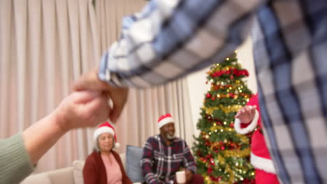 Felices-Y-Diversos-Amigos-Mayores-Vestidos-Con-Traje-De-Papá-Noel-Y-Sombreros-Navideños-Bailando-Y-Mirando,-En-Cámara-Lenta