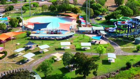 오스트레일리아의 다윈 북부 영토에 있는 리니어 워터파크의 공중 드론 (aerial drone of leanier waterpark awnings pool and slides in darwin northern territory)