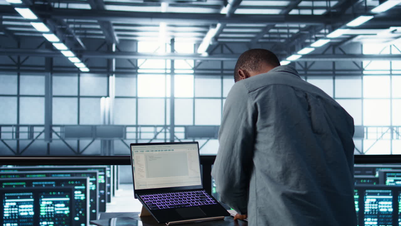 Data center engineer coding on notebook, adjusting power settings