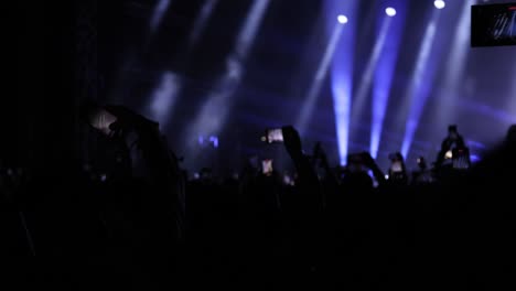 fans capture live concert footage on smartphones as singer performs on illuminated stage