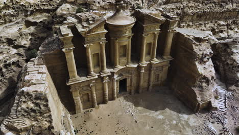 Aerial-view-away-from-the-Ad-Deir-monastery,-in-sunny-Petra,-Jordan---reverse,-tilt,-drone-shot