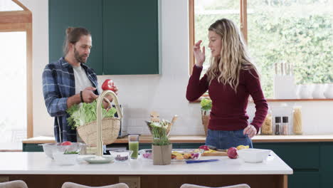 Happy-diverse-couple-unpacking-shopping-in-kitchen-at-home,-in-slow-motion