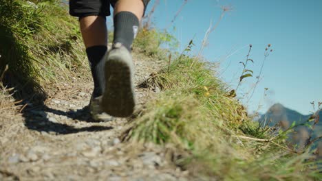 A-man-is-walking-up-an-exposed-alpine-trail-in-slow-motion