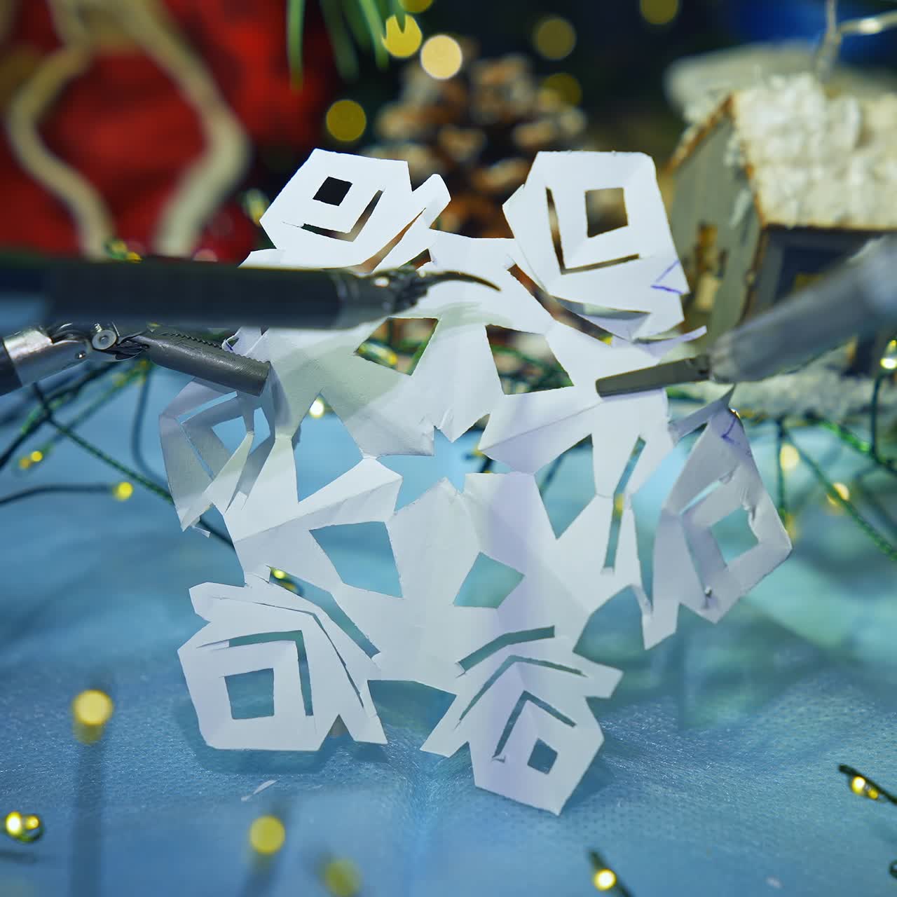 Robotic tool cutting paper snowflake. Smart robot making Christmas decorations. Modern intelligent equipment preparing for New Year