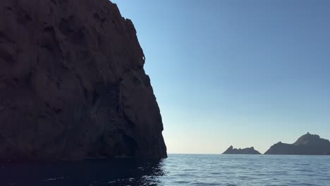 enorme roca en medio del mar en la reserva natural de la península de scandola en la temporada de verano como se ve desde un barco en movimiento, isla de córcega en francia