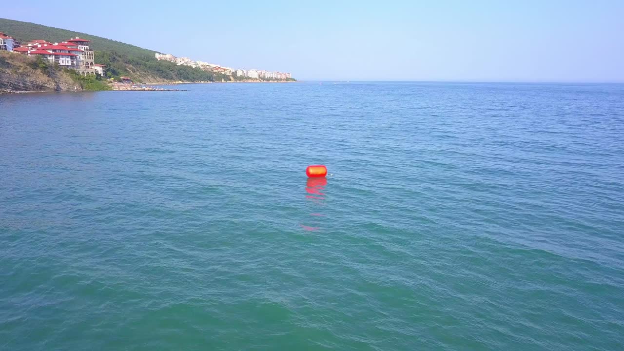 hermoso drone dando vueltas video de boya naranja en el mar
