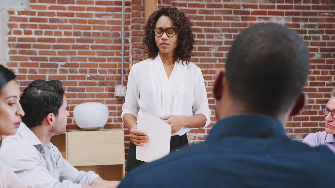 Businesswoman Standing And Leading Office Meeting Around Table