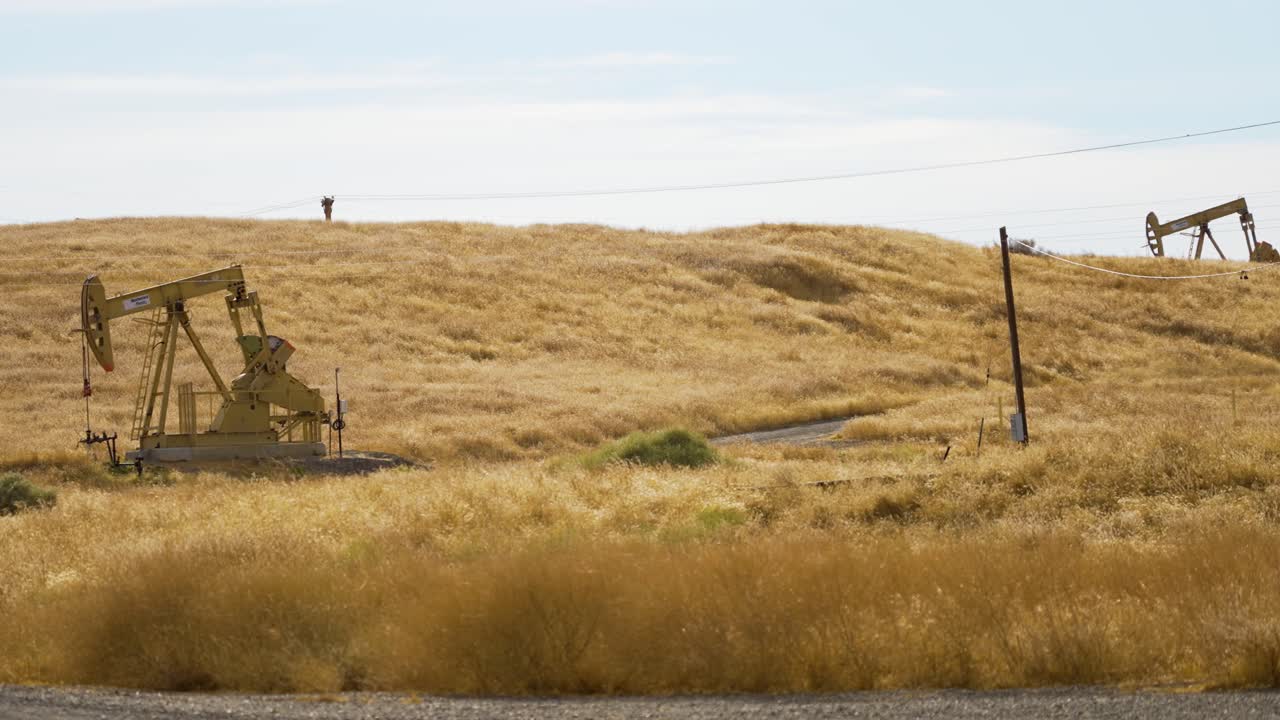 video de 4k de dos plataformas petroleras trabajando en la ladera dorada