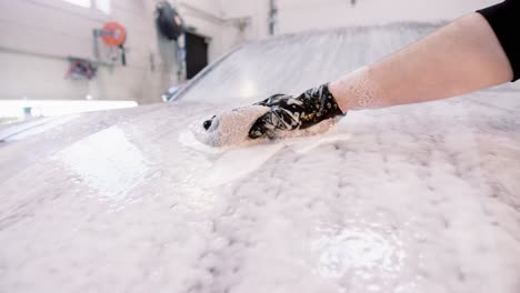 Scrubbing-soap-across-red-car-hood