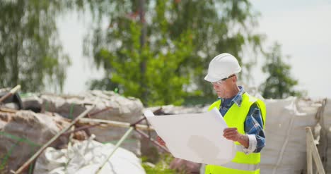 Selbstbewusster-Reifer-Männlicher-Ingenieur,-Der-Blaupause-Analysiert-10