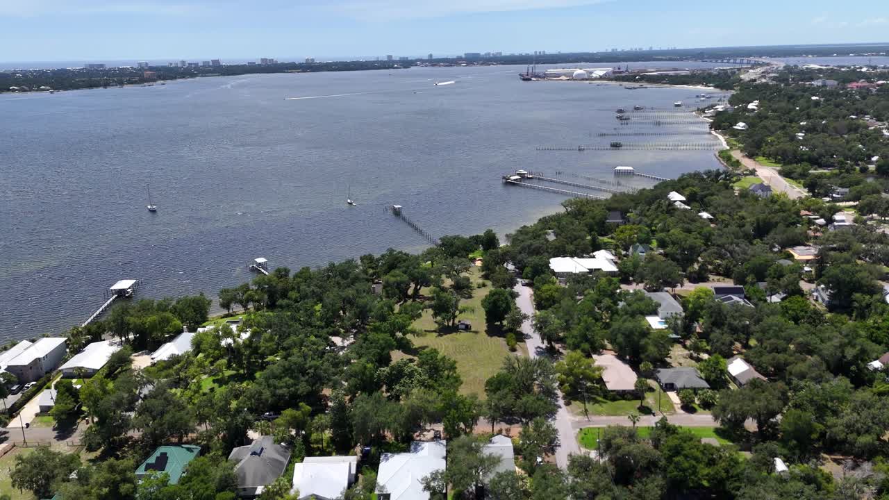Panoramic drone movement over the coastal side of Panama City Beach with forested shoreline, Florida, USA