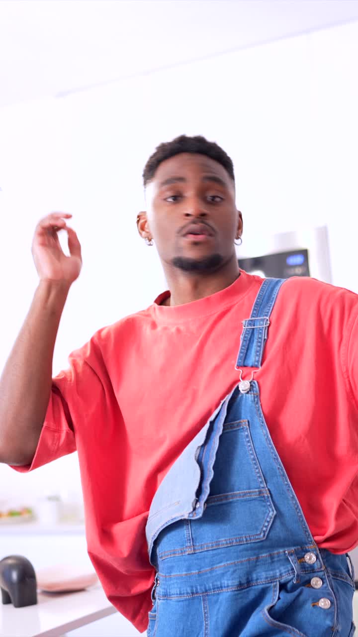 Man in overalls and t-shirt in a kitchen