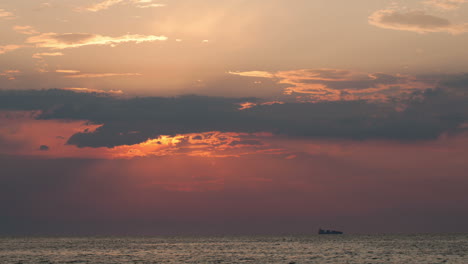 lapso de tiempo de la puesta de sol sobre el mar y el velero