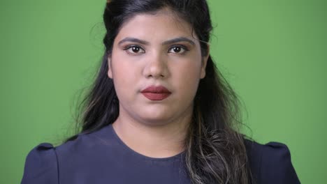 joven sobrepeso hermosa mujer de negocios india contra fondo verde