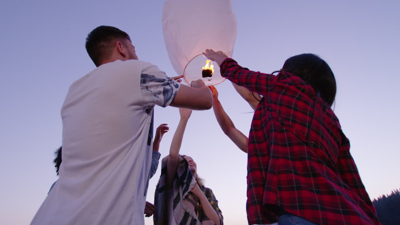 저녁에 하늘의 등불을 발사하는 친구들