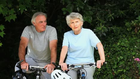 Elderly-couple-walking-with-their-bikes