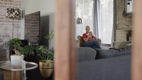 happy biracial woman drinking coffee at home in slow motion