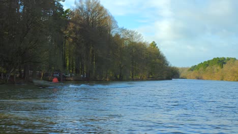 Un-Barco-De-Madera-Navegando-A-Través-Del-Estanque-En-Etang-Saint-Nicolas-En-Angrys,-Francia