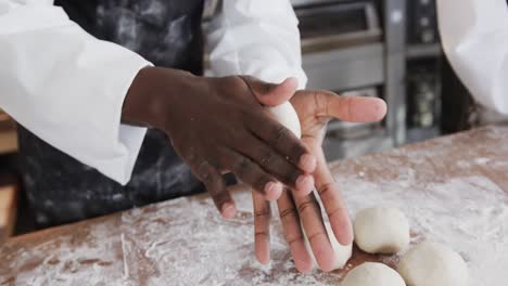 diverse bakers working in bakery kitchen, making rolls from dough in slow motion